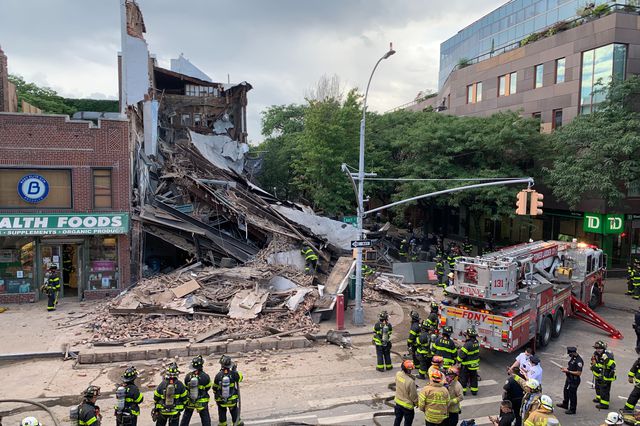 The debris from the collapse building, with Firefighters surrounding it